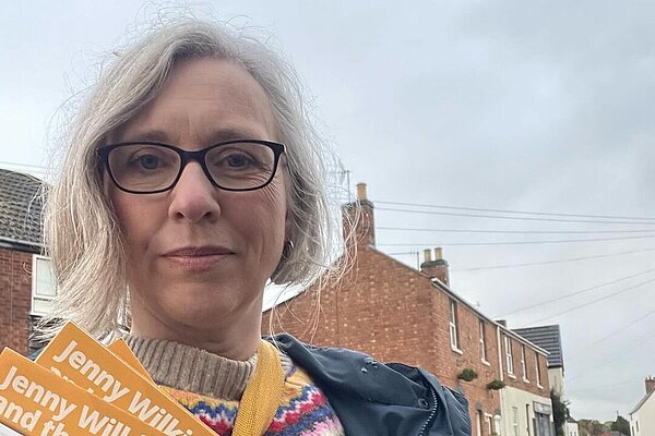 Jenny with Focus leaflets delivering leaflets in Cubbington, houses in the background