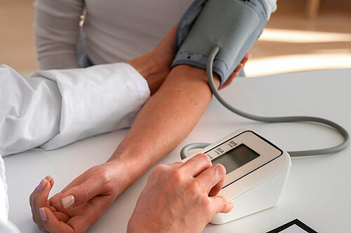 Photo shows patient having their blood pressure taken.