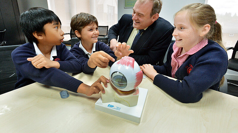 Ed Davey talking to children in a classroom